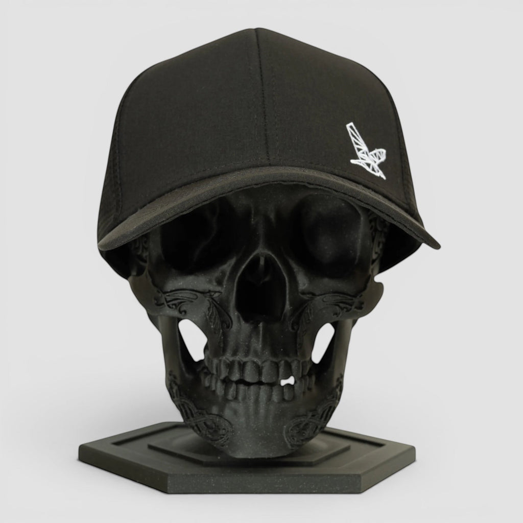 Night Heron Israel black baseball cap with white embroidered logo on a black skull display stand